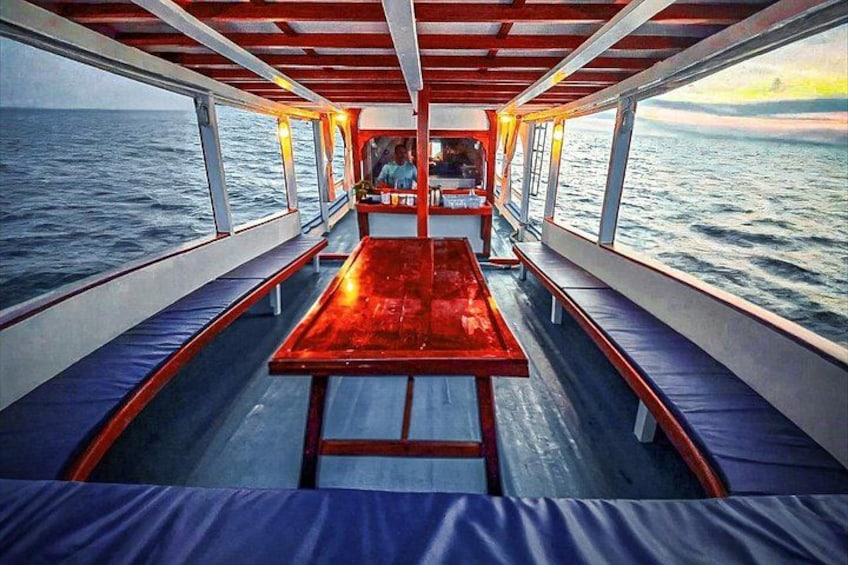 A boat with a wooden table and benches, set against a body of water. 4