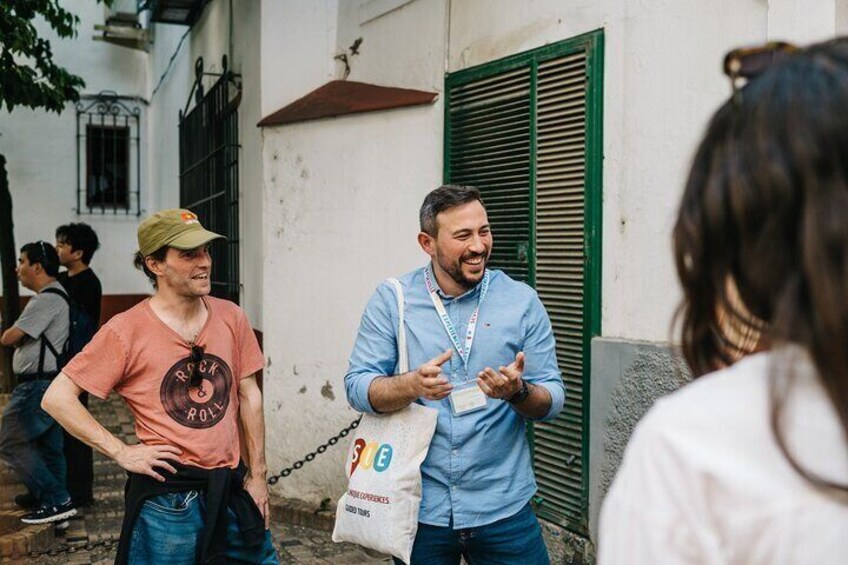 Dos personas conversando al aire libre, una sosteniendo una bolsa blanca con logotipos. 2