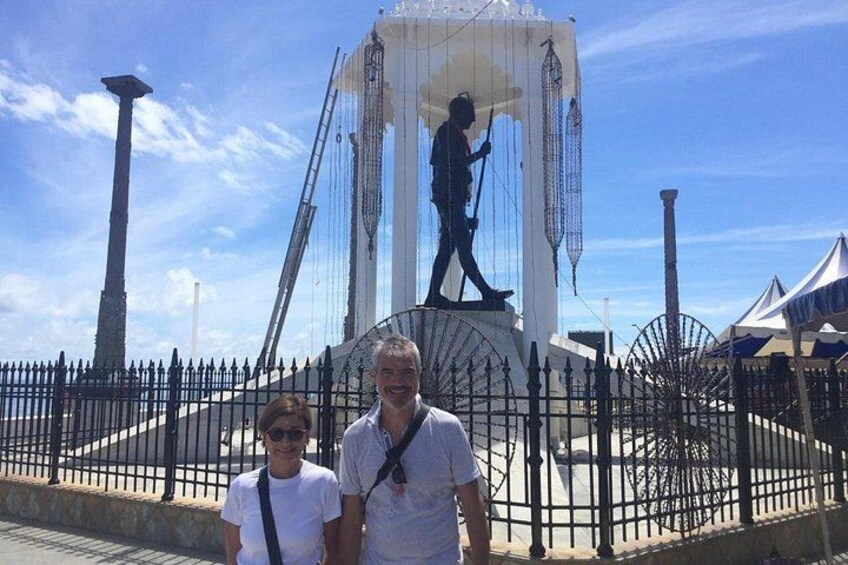 A statue of a man on a pedestal with a fence around it. 4