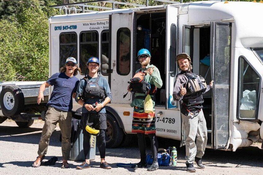 Four people standing in front of a white truck with the text "White Water Rafting" and a phone number. 3