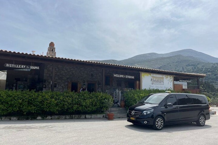 Un edificio de destilería con un automóvil estacionado adelante. 2