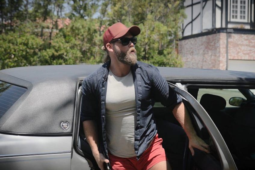 Una persona sale de un automóvil con un edificio y árboles al fondo. 5