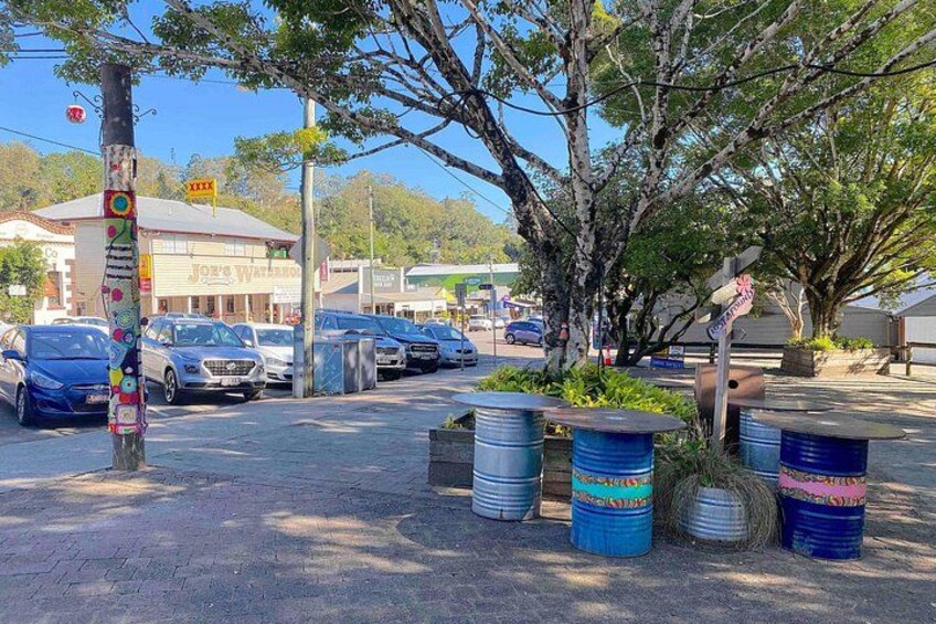 A parking lot with cars, trees, and a building with a sign. 2