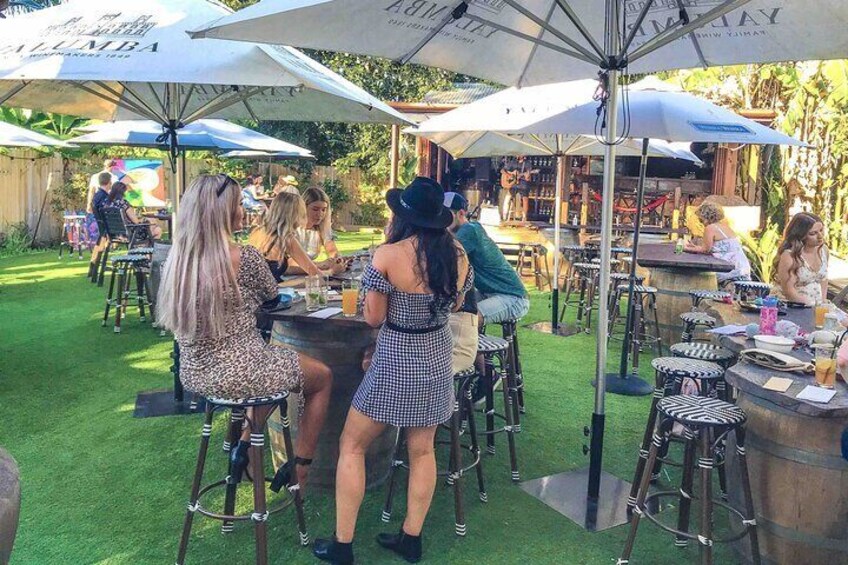 People dining outdoors at a restaurant with umbrellas and outdoor seating. 3
