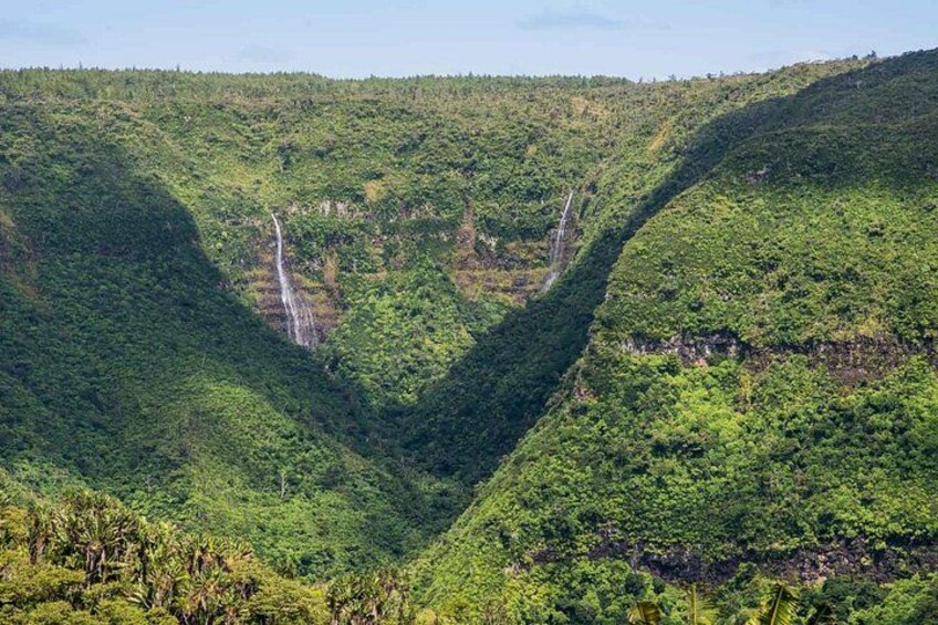 A lush green valley with a waterfall. 4