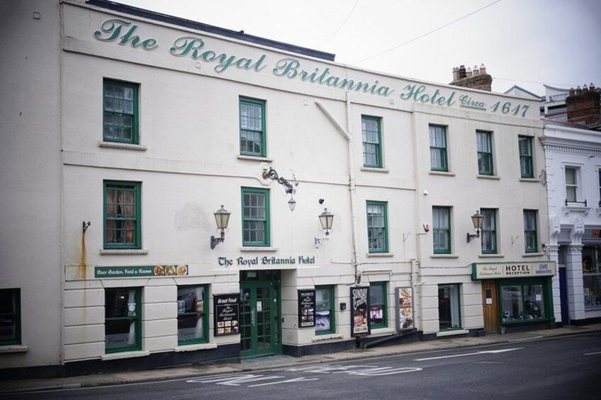The Royal Britannia Hotel, a historic building with green window frames and a white facade. 2