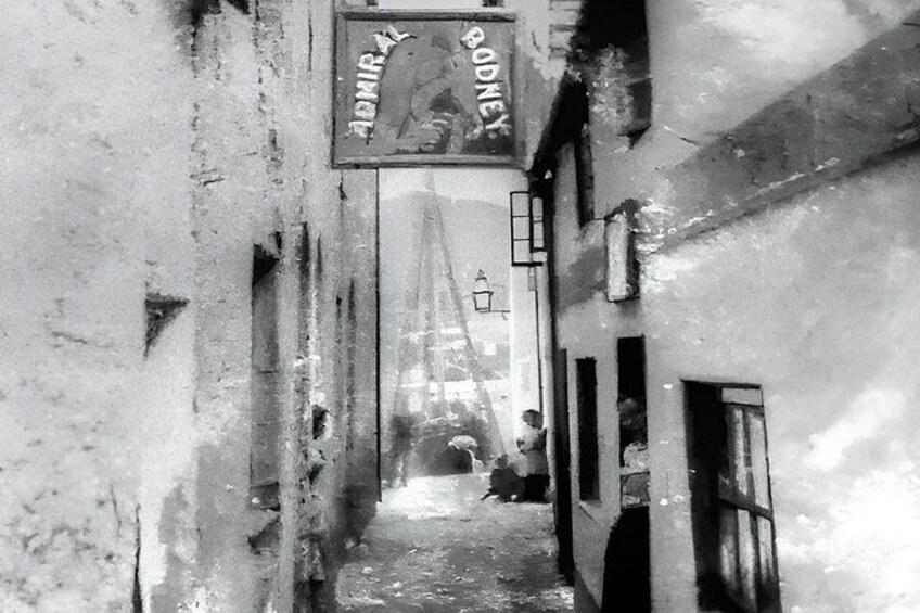 A narrow alleyway with a sign reading 'RODNEY' and a building with a window. 4