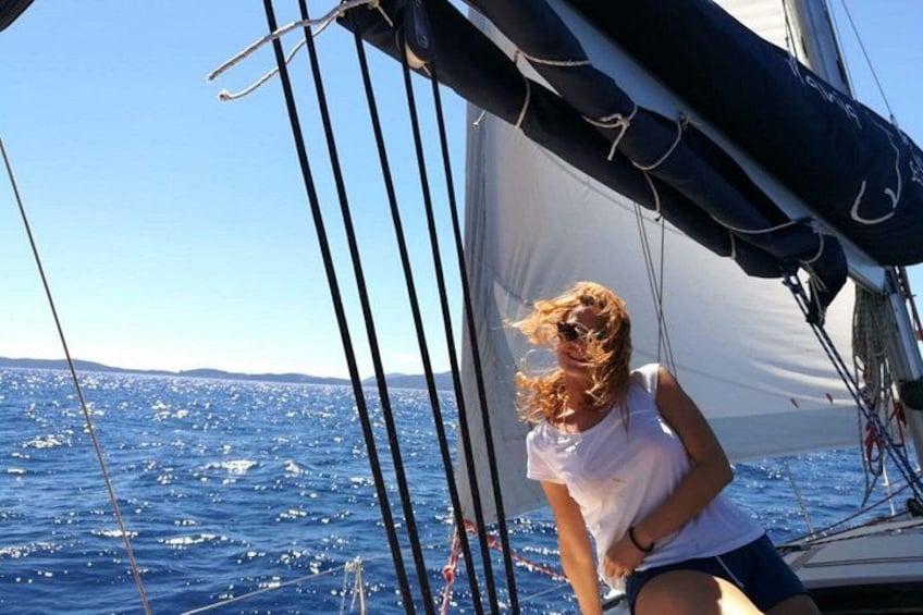 A person on a sailboat with a clear blue sky and calm sea. 4