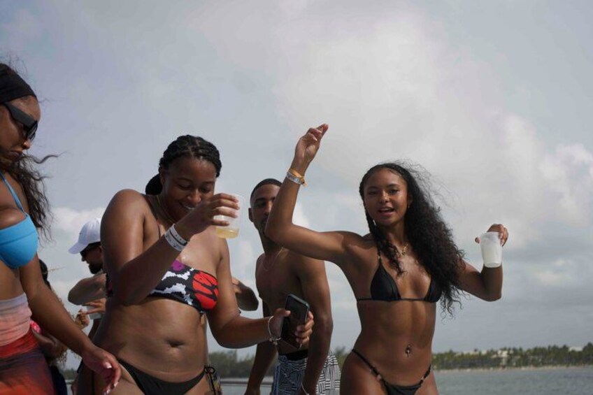 Personas en una playa con agua y cielo nublado. 3