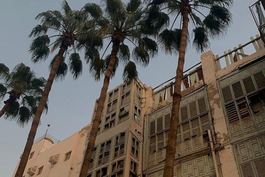 Un edificio con varias ventanas y palmeras en primer plano. 3