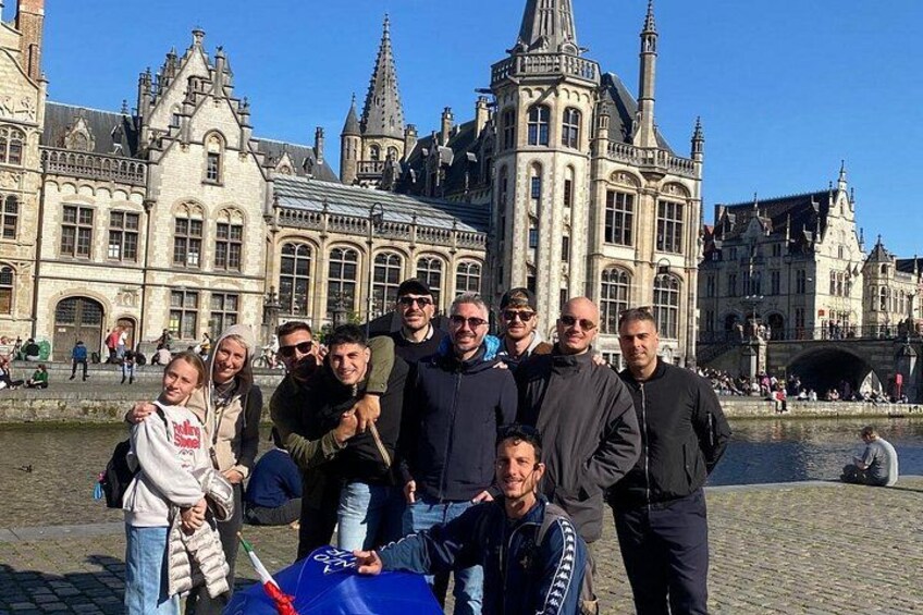 A group of people posing in front of a historic building with intricate architecture. 2