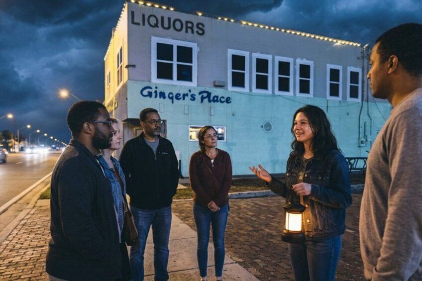 A group of people standing in front of a building with 'Ginger's Place' written on it. 4