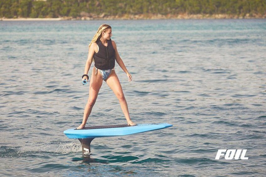 A person standing on a blue surfboard in the water. 3
