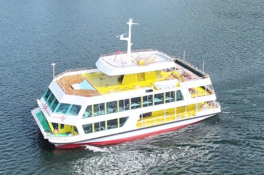 Un grand navire de croisière fluviale à plusieurs ponts, arborant une décoration aux couleurs blanche et jaune, une coque rouge et un drapeau à la poupe. 2