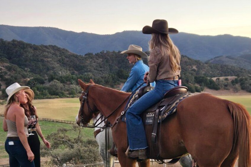 Deux personnes à cheval, sur un sentier, avec un paysage montagneux en arrière-plan. 5