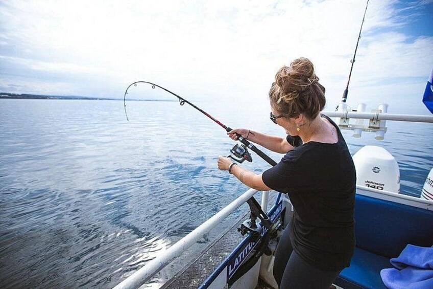 Une personne pêchant sur un bateau, sur une eau calme, sous un ciel dégagé. 1