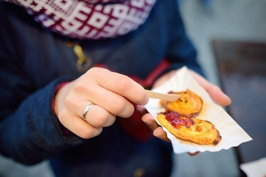 A person holding a piece of food with a fork. 3