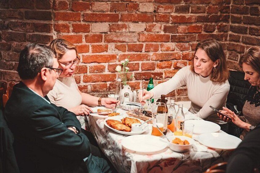 En grupp människor som sitter vid ett bord och äter och dricker. 3