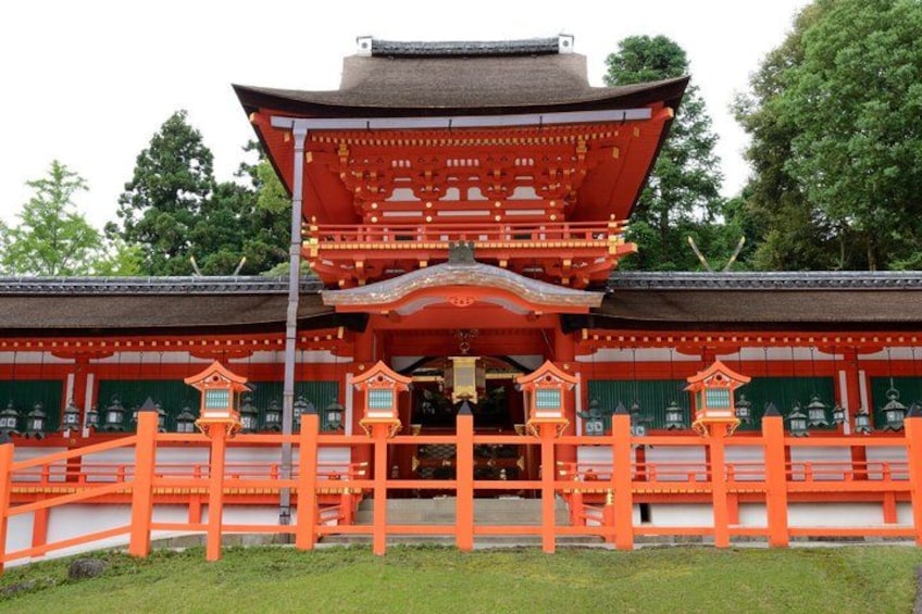 A traditional Japanese building with a red roof and white walls, surrounded by a wooden fence. 2