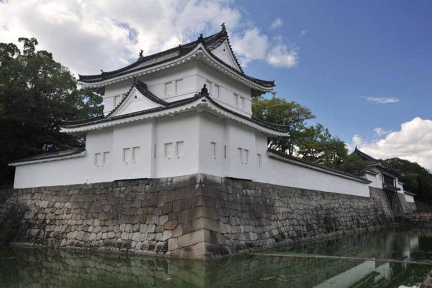 A white castle with a stone base, surrounded by water. 3