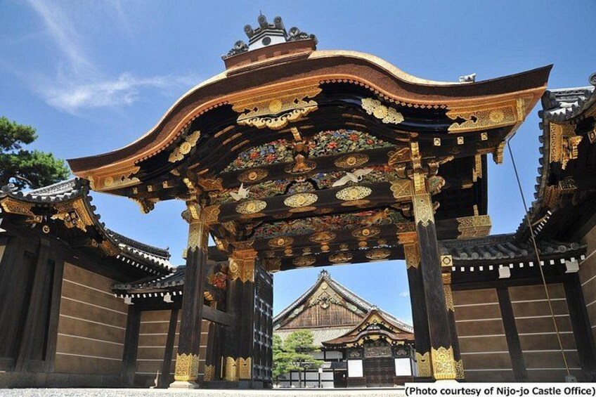 A traditional Japanese gate with ornate decorations and a castle in the background. 4