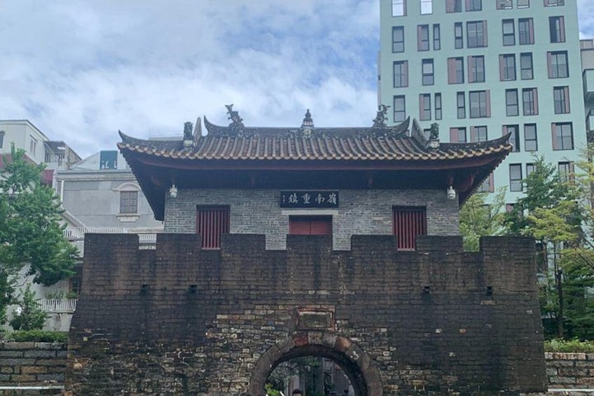 A traditional Chinese building with a tiled roof and brick walls, featuring a sign with Chinese characters. 2