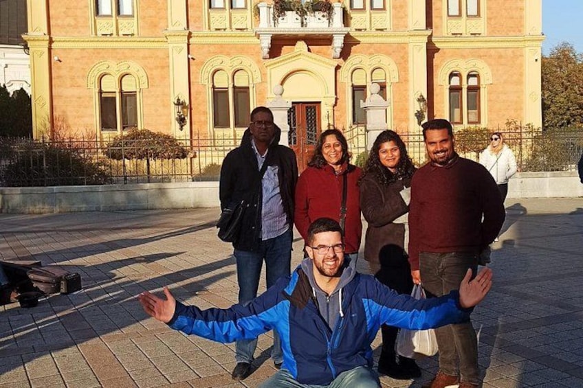 A group of people posing in front of a historic building with ornate architecture. 3