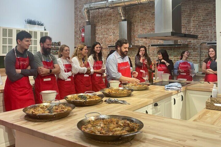 Un groupe de personnes portant des tabliers se trouve dans une cuisine, et des casseroles sont posées sur le plan de travail. 5