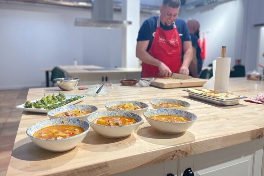 A kitchen with bowls of food and a person cooking. 5