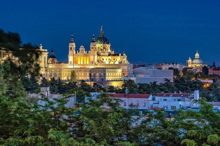 Una maestosa cattedrale con numerose cupole e torri, immersa nel verde e circondata da edifici moderni. 1