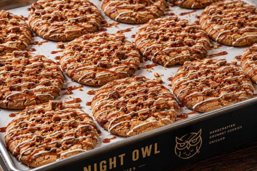 En bakke med bagværk, drysset med glasur og nødder, mærket 'NIGHT OWL Handmade Gourmet Cookies Chicago'. 2