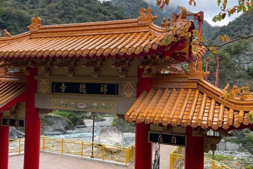 A traditional Chinese gate with intricate roof design and calligraphy. 2