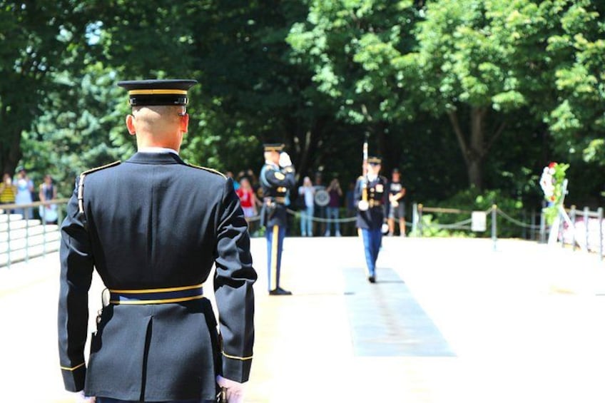 En militärceremoni där en officer i uniform står i förgrunden och en annan i bakgrunden. 1