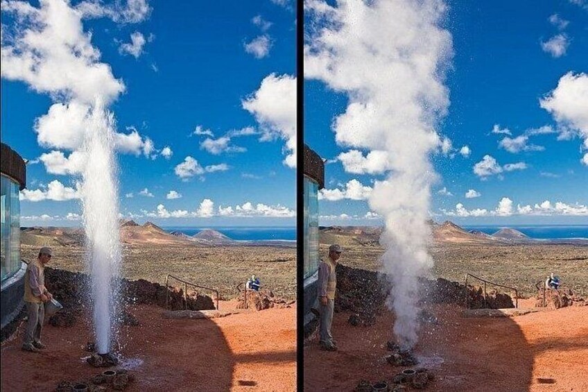A geyser eruption with a clear sky and distant mountains. 4
