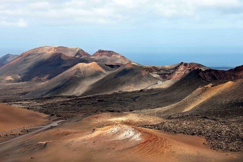 A barren landscape with rolling hills and a distant view of the ocean. 5