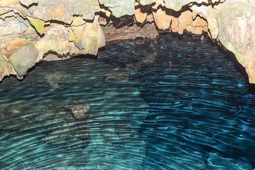 A cave with clear water and rocky formations. 3