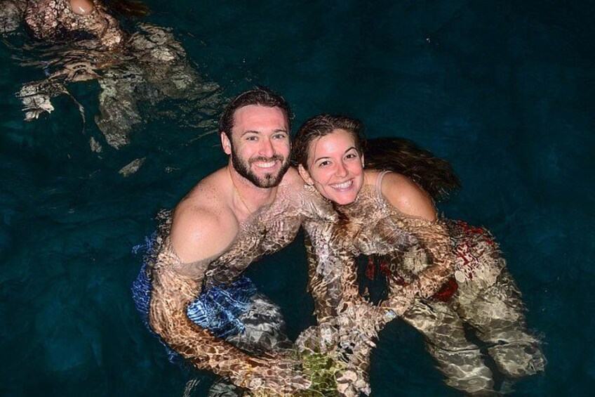 Dos personas en una piscina con rocas y plantas acuáticas. 3