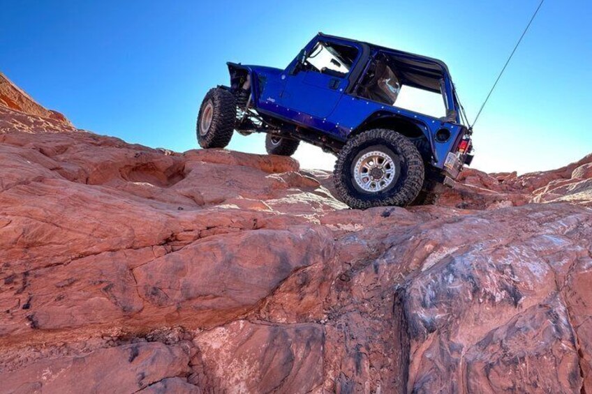 A blue off-road vehicle on rocky terrain. 3