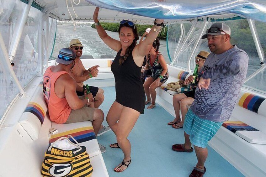 A boat with people on board, some holding drinks, and a bag with a logo. 2