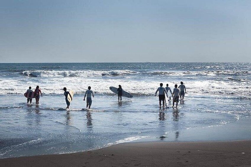 People walking on a beach with surfboards. 5