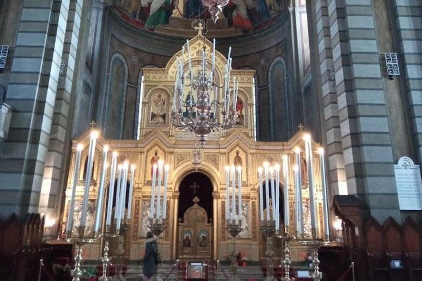 Ein prächtiges Kircheninnere mit einem großen Chandelier, einem aufwendig verzierten Altar und zahlreichen Kerzen. 4