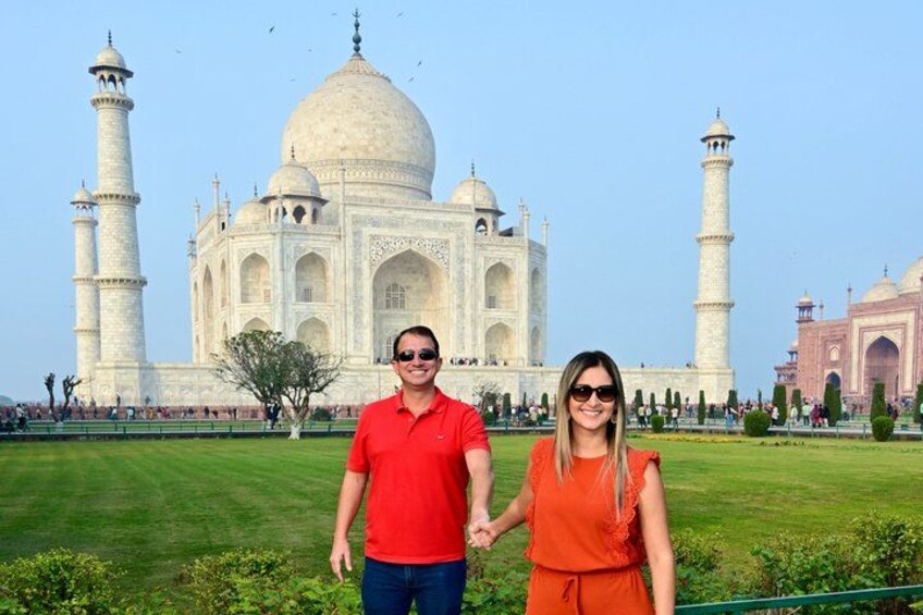 Un couple se tient devant le Taj Mahal. 1
