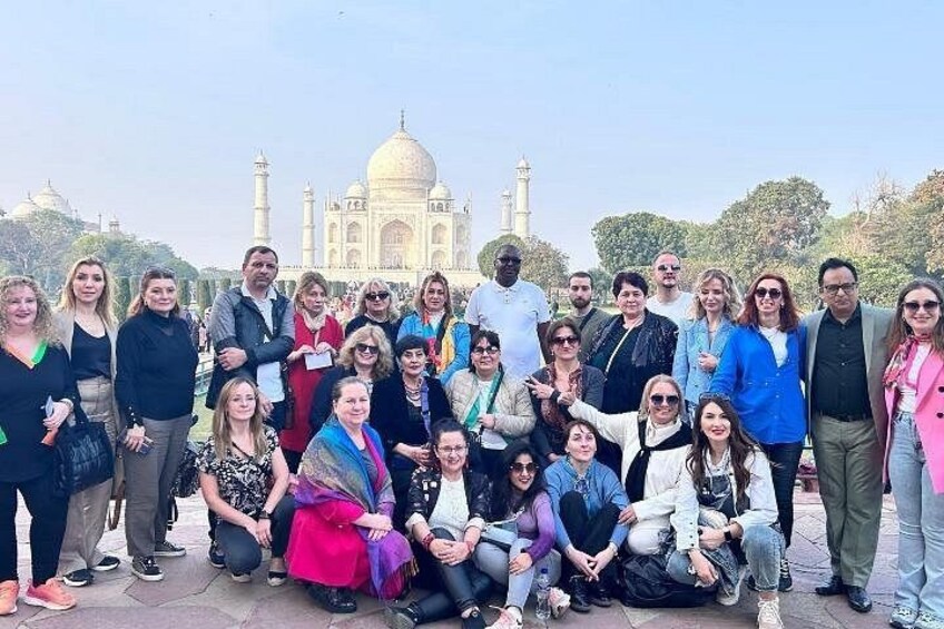 Eine Gruppe von Personen posiert vor dem Taj Mahal. 3