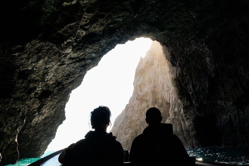 Deux personnes sont assises à l’intérieur d’une grotte, d’où l’on aperçoit une montagne. 3