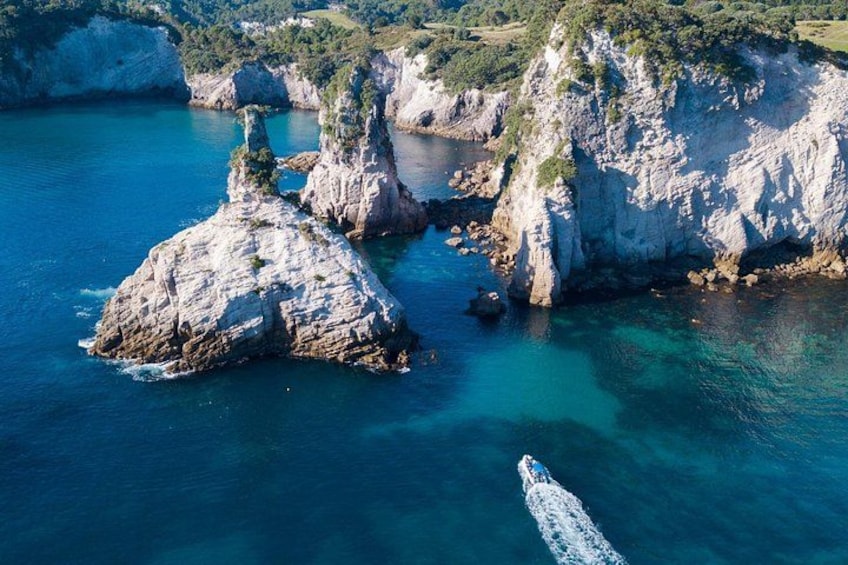 A coastal landscape with rocky cliffs and clear blue waters. 4