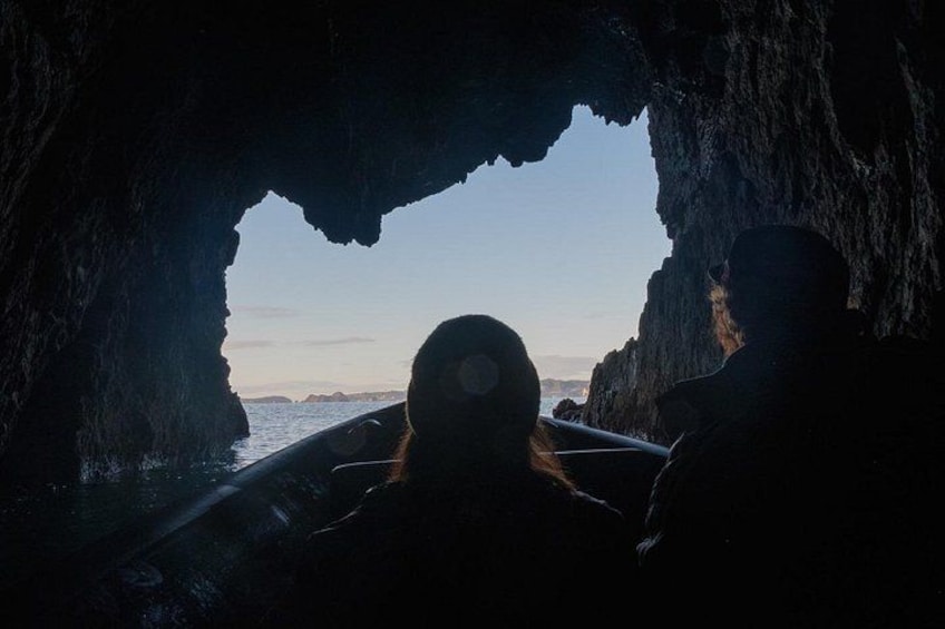 A cave opening to a body of water with rocky walls. 3