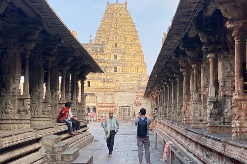 A temple with a tall, tiered tower, stone steps, and columns. 2