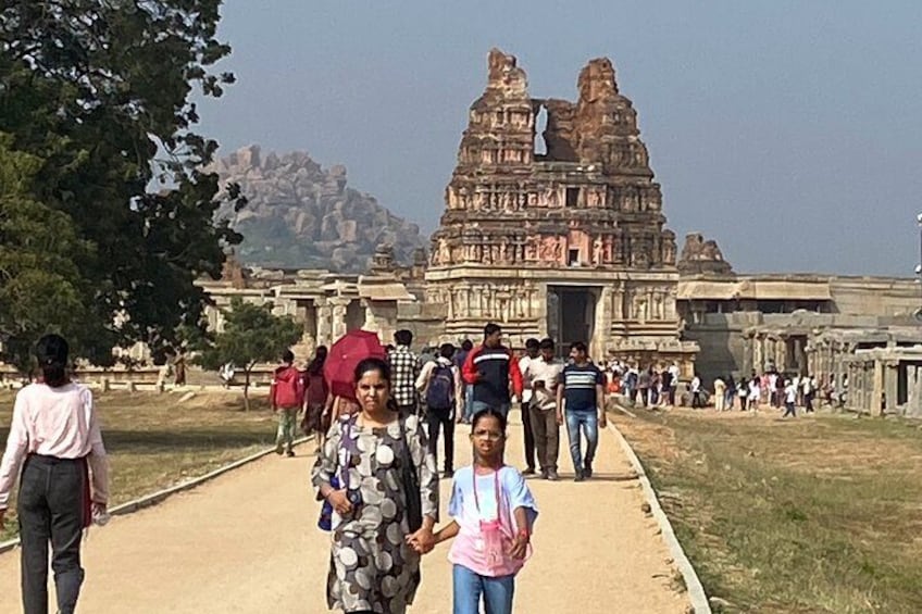 A group of people walking towards a large, ancient temple with intricate carvings. 3