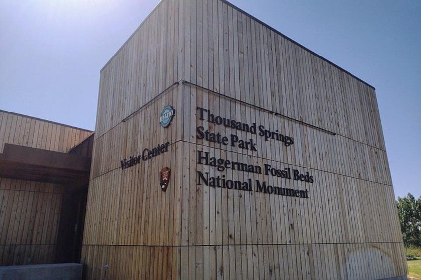 A wooden building with signs for Thousand Springs State Park and Hagerman Fossil Beds National Monument. 3