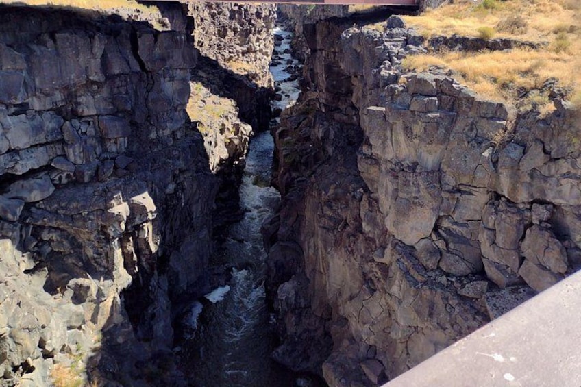 A deep canyon with steep rock walls and a narrow passageway. 5